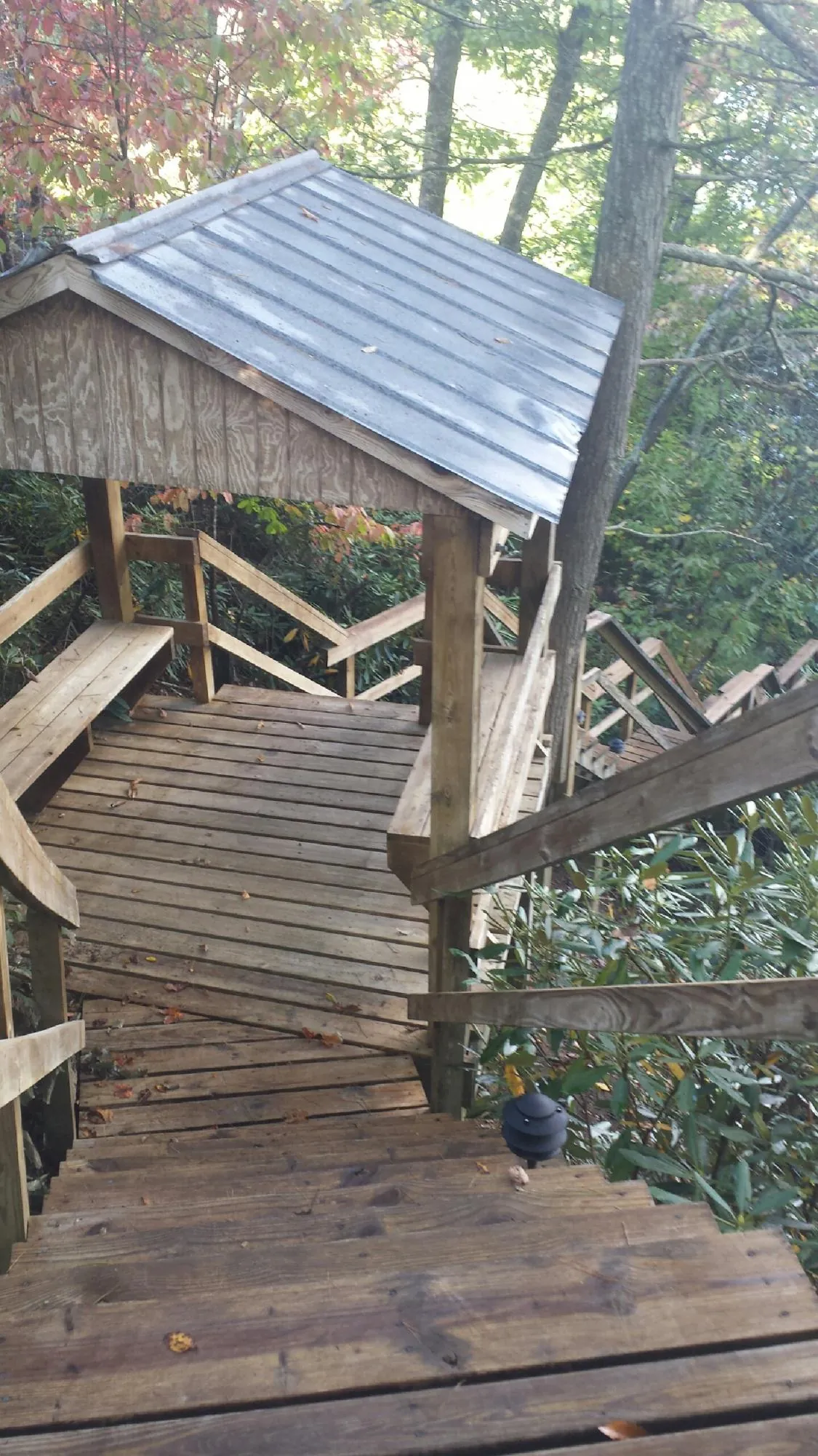 Metal roofed shelter over wooden steps on a wooded walkway — Skylight Repair & Installation work by our crew in Wallops Island