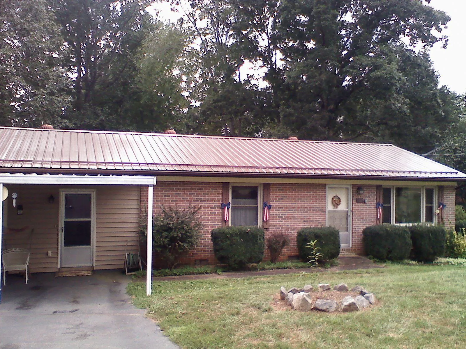 Bronze metal roof and carport on a brick ranch home — Roof Repair work by our crew in Wallops Island
